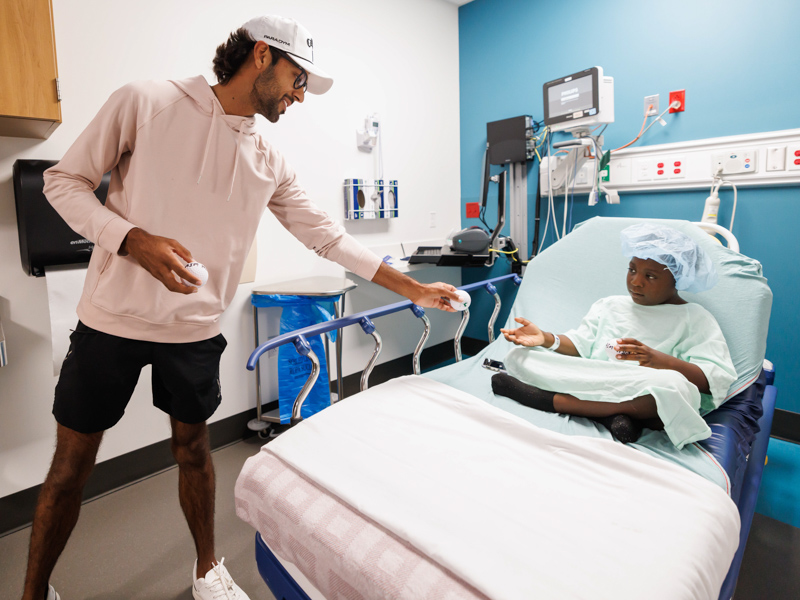 Aiden Anderson of Brandon gets a Sanderson Farms Championship golf "stress" ball from professional golfer Akshay Bhatia during a visit to Children's of Mississippi. Melanie Thortis/UMMC Photography